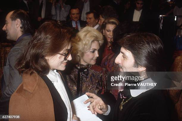 French movie actress Anouk Aimee talks with French fashion designer Emmanuel Ungaro at his Spring-Summer 1983 fashion show in Paris. Ungaro presented...