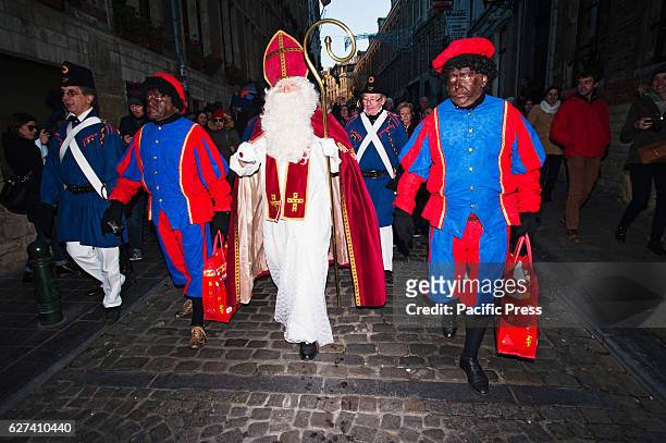 Saint-Nicholas and his two helpers dressed traditionally as Black Pete characters walk through Brussels on the annual Saint-Nicholas parade. The...