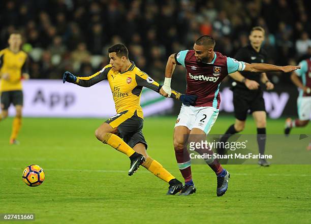 Alexis Sanchez of Arsenal breaks past Winston Reid of West Ham during the Premier League match between West Ham United and Arsenal at London Stadium...