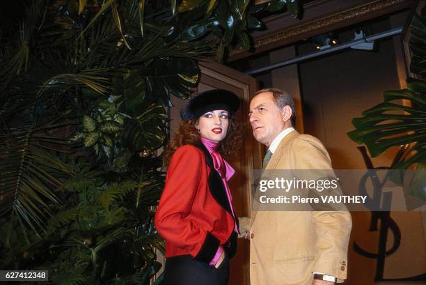 Pierre Berge, co-founder of French fashion house Yves Saint Laurent, stands on the runway with a model during the company's 1981-1982 Fall-Winter...