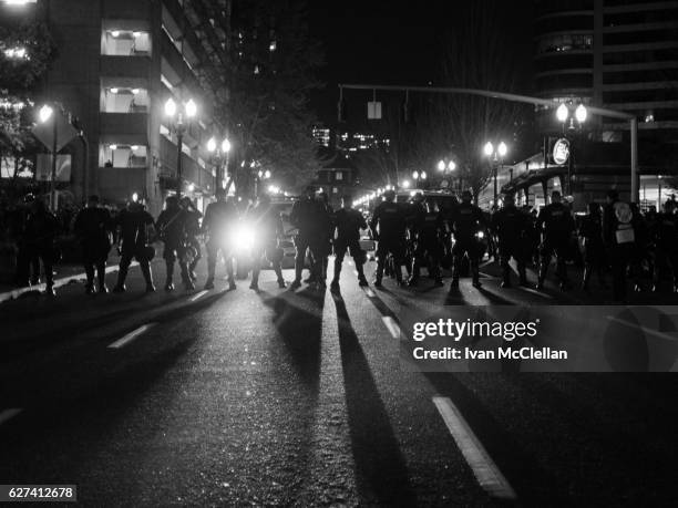 line of police officers in riot gear - police riot gear stock pictures, royalty-free photos & images