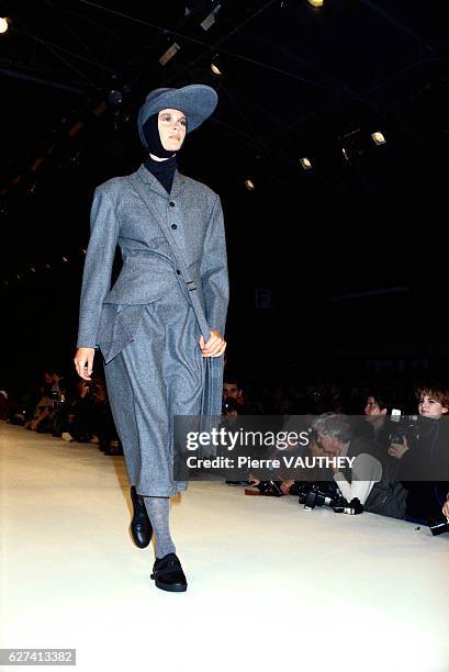 Fashion model wears a gray blazer and short pants with a hat by Japanese fashion designer Yohji Yamamoto at his autumn-winter 1986-1987 fashion show...