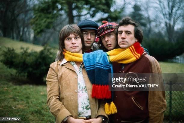 Comedians from the British comedy troupe Monty Python pose with a large scarf around their necks during a visit to Paris. : Terry Gilliam, musician...