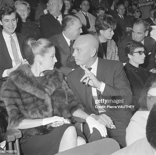 Actor Yul Brynner and his wife Doris Kleiner chat together while at the theater. Seated behind Kleiner is actor Anthony Perkins.