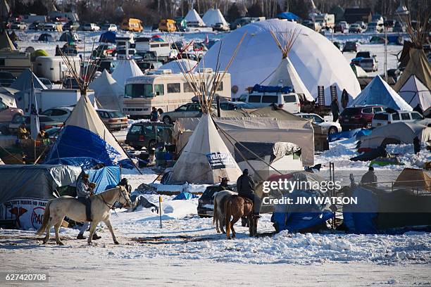 Activists on horseback pass through the Oceti Sakowin Camp on the edge of the Standing Rock Sioux Reservation on December 3, 2016 outside Cannon...