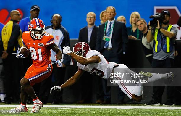 Antonio Callaway of the Florida Gators breaks the takle of Minkah Fitzpatrick of the Alabama Crimson Tide in the first quarter during the SEC...