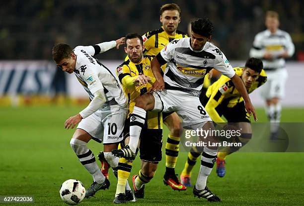 Thorgan Hazard of Borussia Moenchengladbach and Mahmoud Dahoud of Borussia Moenchengladbach challenge Gonzalo Castro of Borussia Dortmund during the...