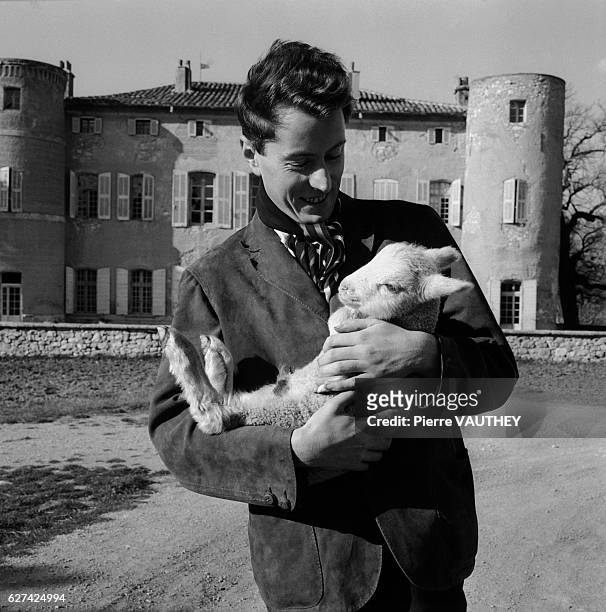 French painter Bernard Buffet cradles a baby goat at the Chateau l'Arc in Aix-en-Provence. Buffet's figurative paintings were associated with the...