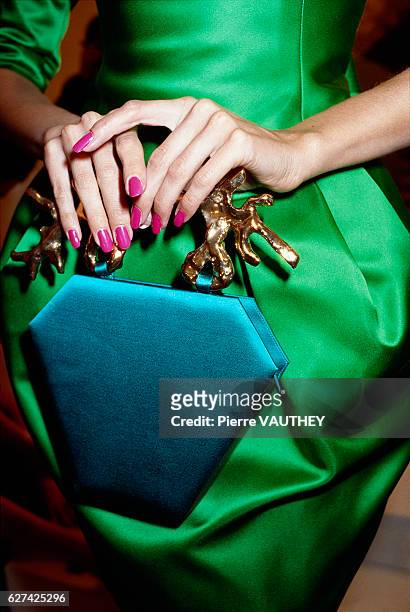 Fashion model holds a purse by French fashion designer Christian Lacroix during rehearsals for his 1987-1988 Fall-Winter fashion show. The latest...
