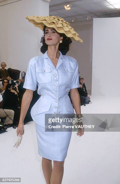 Fashion model wears a pastel haute couture suit by German fashion designer Karl Lagerfeld for French fashion house Chanel. She is modeling the suit...