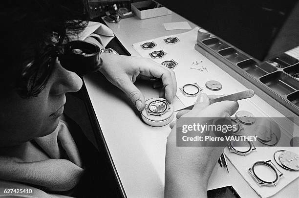 Watchmaker uses magnifying eyewear and precision tools to assemble watches in the Omega watch factory in Biel-Bienne, Switzerland.