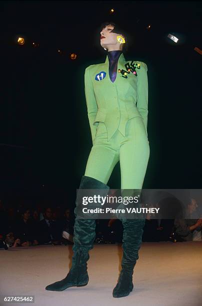 Fashion model wears a ready-to-wear lime green pantsuit by German fashion designer Thierry Mugler. She is modeling the suit during his Autumn-Winter...