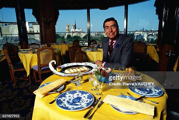 Claude Terrail, owner of Tour d'Argent restaurant, sits at a dining table in his famous establishment. The Cathedral of Notre Dame de Paris can be...