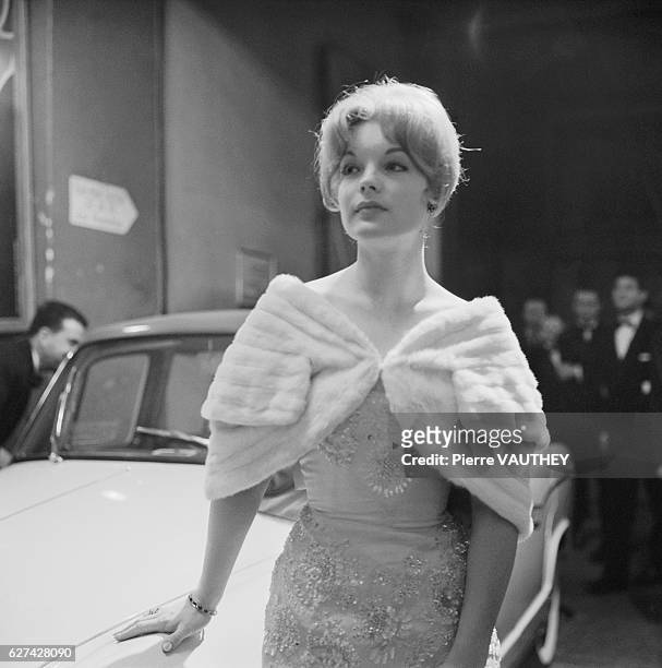 Austrian actress Romy Schneider wears a beaded evening gown and fur stole for the opening night of a play. She attended the premiere with her mother,...
