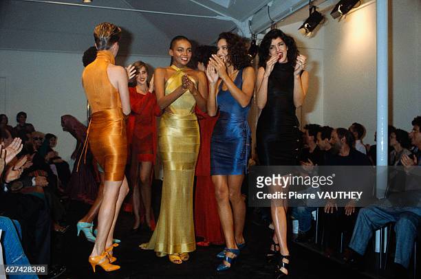 Group of models applaud Tunisian designer Azzedine Alaia at his 1986 spring-summer women's fashion show in Paris. The models are wearing colorful...