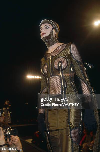 Fashion model wears a barebreasted, ready-to-wear dress decorated with zippers by French fashion designer Jean Paul Gaultier. She models the dress...