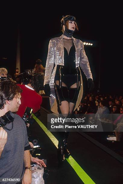 Fashion model wears a ready-to-wear corset outfit with a silver jacket by French fashion designer Jean Paul Gaultier. She models the outfit during...