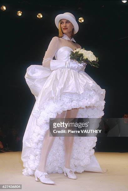 Fashion model wears a white haute couture wedding dress and brimmed hat by French fashion designer Lolita Lempicka. She modeled the dress during the...