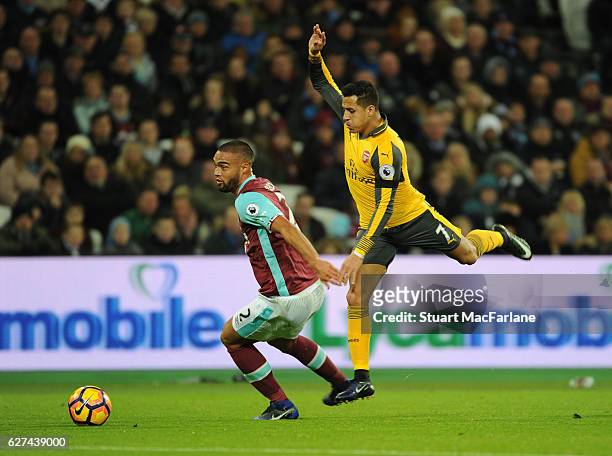 Alexis Sanchez of Arsenal challenges Winston Reid of West Ham during the Premier League match between West Ham United and Arsenal at London Stadium...