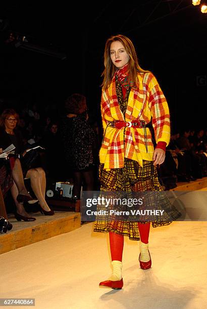 Fashion model wears a plaid blazer and sheer plaid skirt over leggings by Japanese fashion designer Kenzo Takada at his autumn-winter 1987-1988...