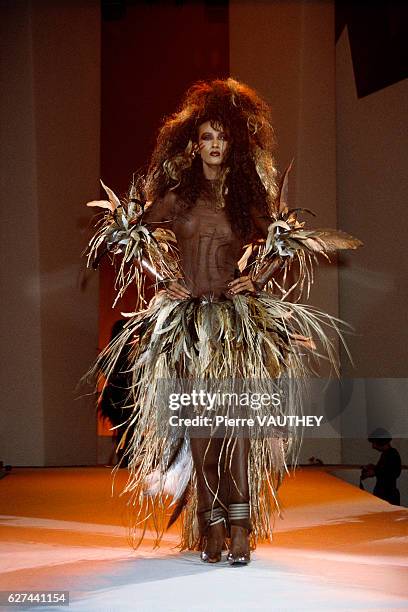 Fashion model Iman wears a feathered dress with sheer bodice by German fashion designer Thierry Mugler at his spring-summer 1988 fashion show in...