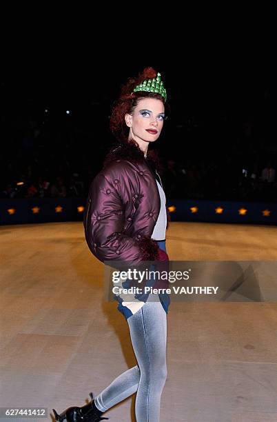 Supermodel Kristen McMenamy wears a ready-to-wear purple jacket with a blue striped skirt and silver tights by French fashion designer Jean Paul...