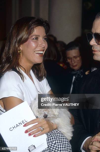 Caroline, Princess of Monaco, holding her pet dog, talks with German fashion designer Karl Lagerfeld at the Autumn-Winter 1988-1989 fashion show in...