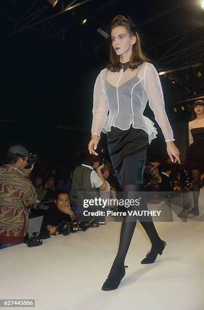 Fashion model wears a ready-to-wear cocktail dress and sheer jacket by French fashion designer Lolita Lempicka. She is modeling the dress during the...