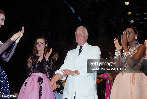 French fashion designer Hubert de Givenchy with a group of fashion models. The models are wearing haute couture cocktail dresses during Givenchy's...