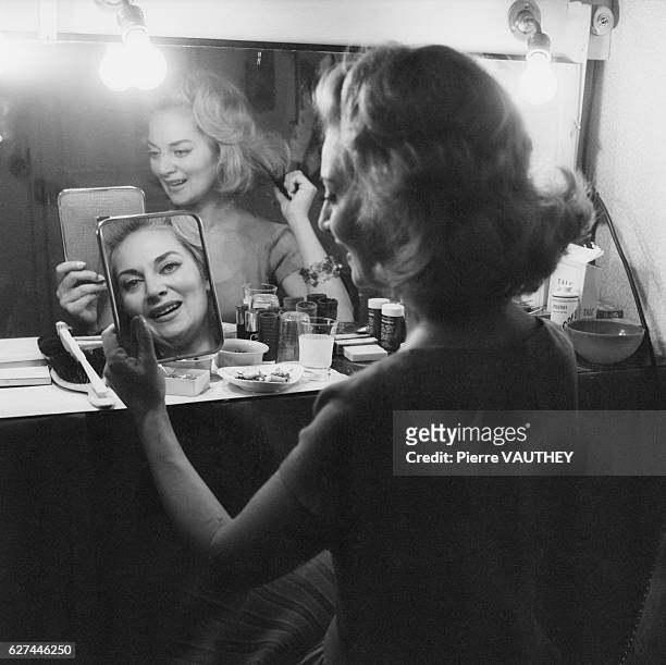 French actress Francoise Christophe looks in at herself in a mirror while in her Paris dressing room.