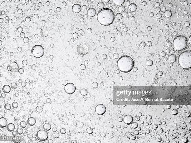 full frame of the textures formed by the bubbles of oil in the shape of circle floating on the water color white - oil liquid ストックフォトと画像