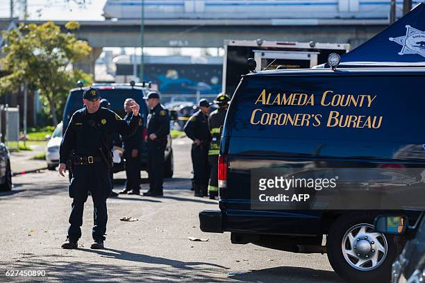 The Alameda County coroner's van is seen near a warehouse after it was destroyed by a fire, December 3, 2016 in Oakland, California. Up to 40 people...