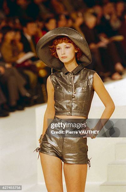 Fashion model wears ready-to-wear women's fashions during a 1997 spring-summer fashion show for French fashion house Chanel. Her outfit includes a...