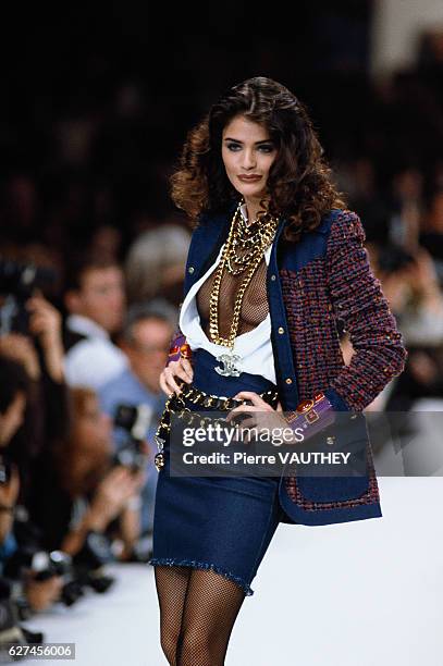 Supermodel Helena Christensen wears a ready-to-wear blazer and denim skirt over a fishnet bodysuit by German fashion designer Karl Lagerfeld for the...