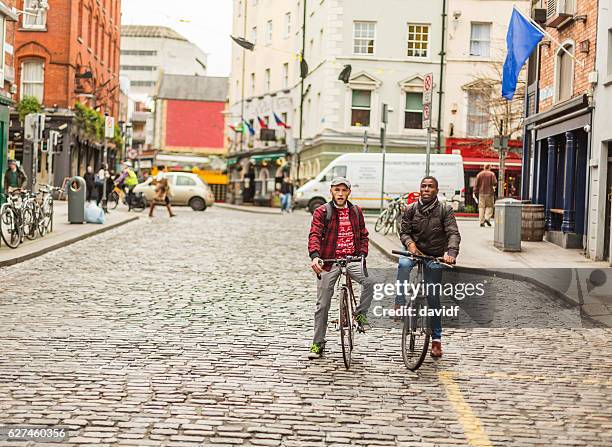 mixed race gay couple with bicycles in the city - dublin street stock pictures, royalty-free photos & images