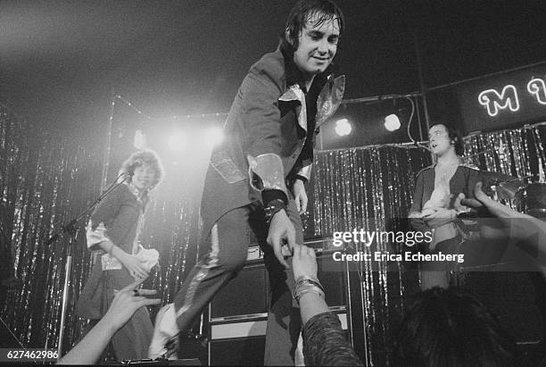 English glam rock band Mud perform on stage in Leicester, United Kingdom, 1975. L-R Rob Davis, Les Gray , Dave Mount.