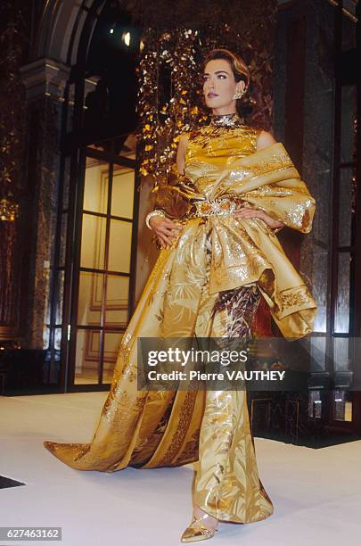 Supermodel Tatjana Patitz models a women's haute couture gold evening gown by Italian fashion designer Gianfranco Ferre for French fashion house...