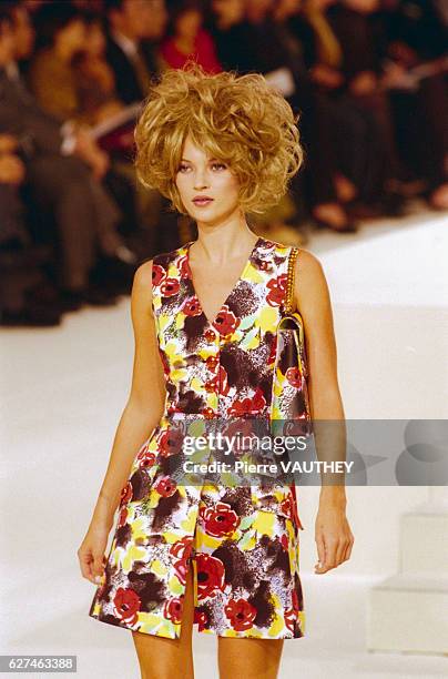 Model Kate Moss wears ready-to-wear women's fashions during a 1997 spring-summer fashion show for French fashion house Chanel. Her outfit includes a...