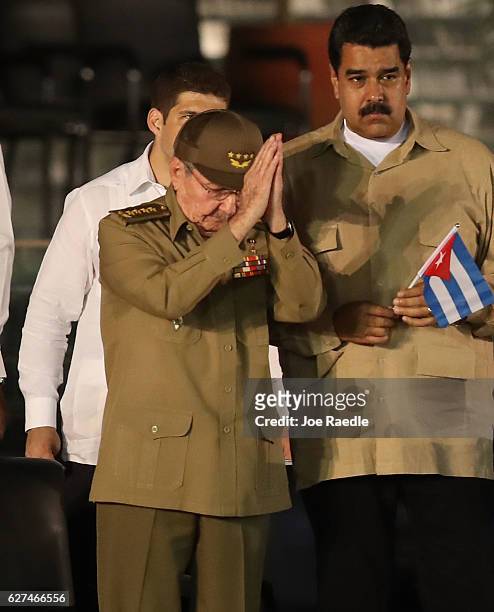 Cuban President Raul Castro acknowledges the crowd as Venezuela's President Nicolas Maduro stands behind him during a memorial tribute for former...