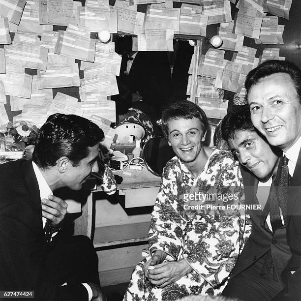 French singer Claude Francois in his dressing room at the Olympia with singers Gilbert Becaud and Sacha Distel and actor Maurice Biraud.
