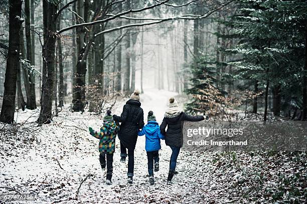 happy family running in beautiful winter forest - weather improve in kashmir after two days of snowfall stockfoto's en -beelden