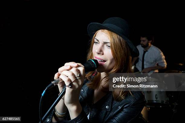 female singer holding microphone performing a song - blonde female singers - fotografias e filmes do acervo