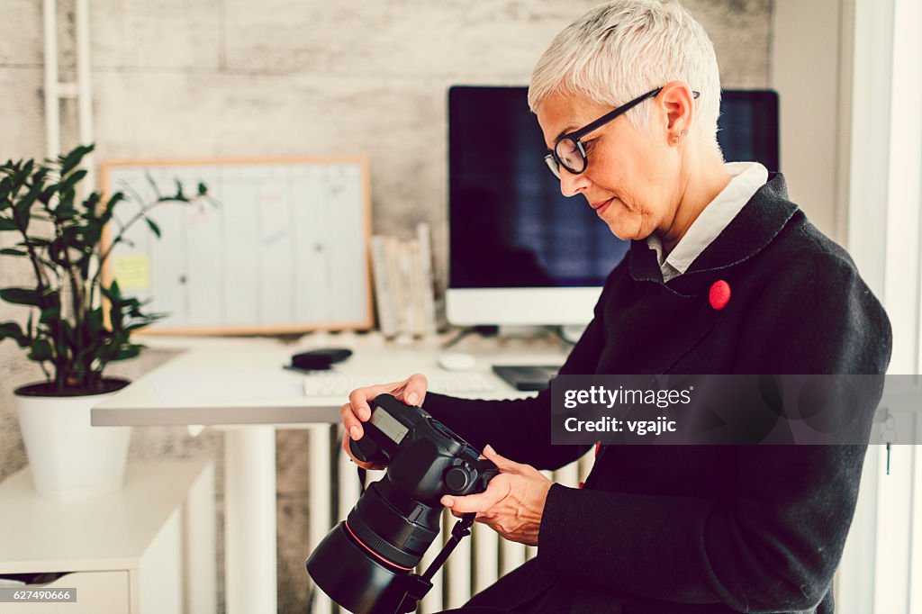 Female Photographer In Her Home Office.