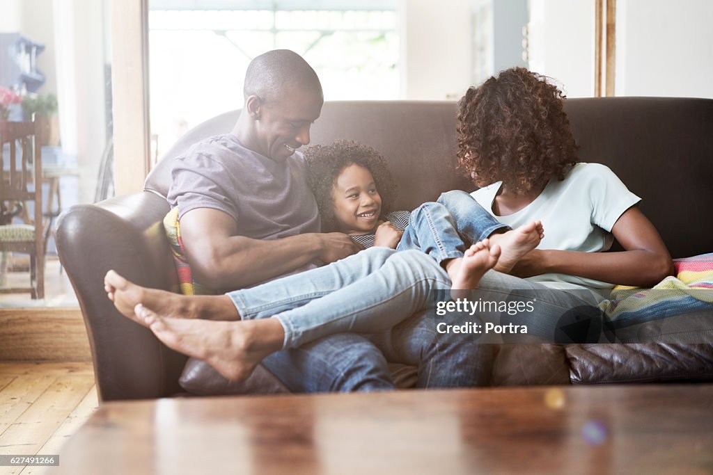 Cheerful family sitting on sofa at home
