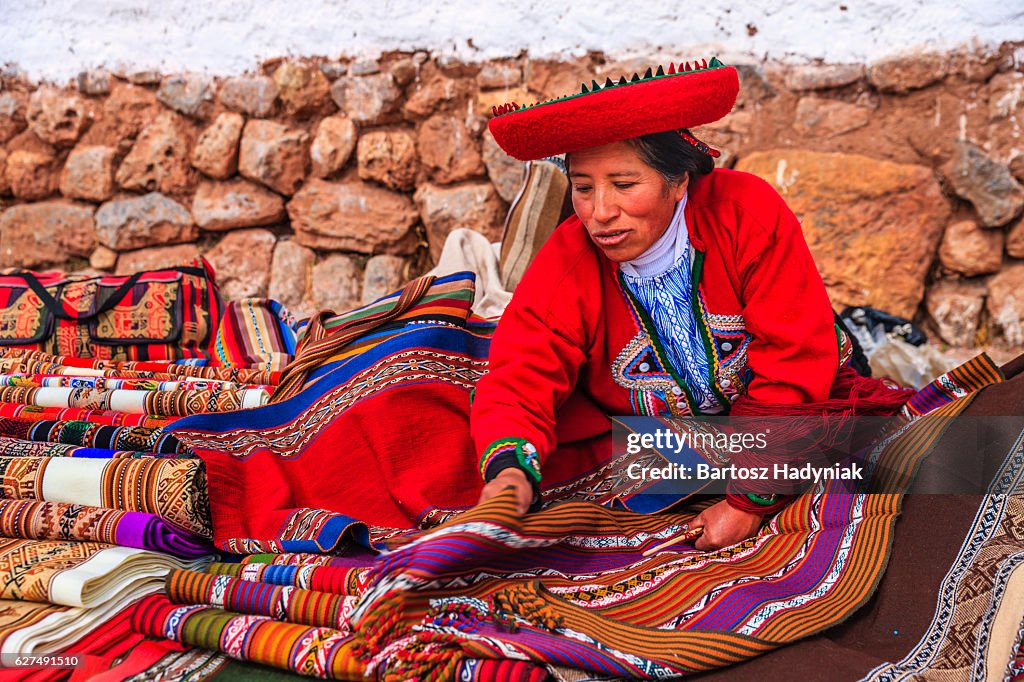 Peruano que vende souvenirs mulher em ruínas incas, o Vale Sagrado, no Peru