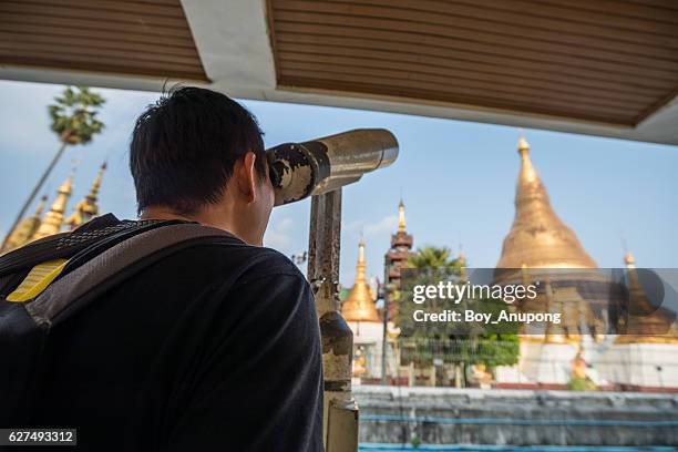 tourist use the binoculars for looking the diamond and precious gem on the top of shwedagon pagoda. - binoculars icon stock pictures, royalty-free photos & images