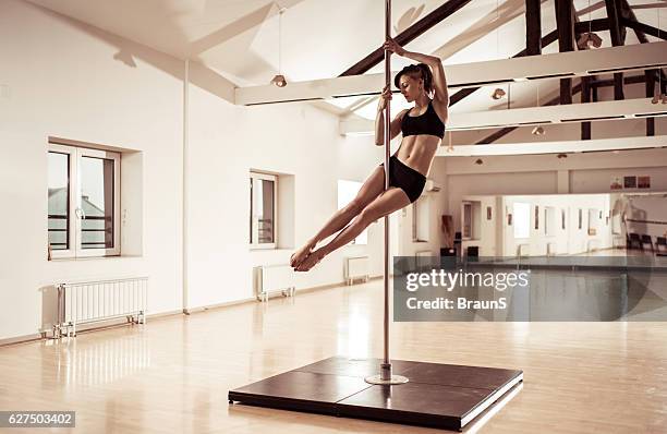 sensual bailarina bailando en un poste en un estudio. - pole dance fotografías e imágenes de stock