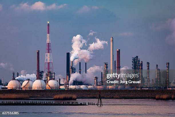 refineries at sunset - pollution stock pictures, royalty-free photos & images