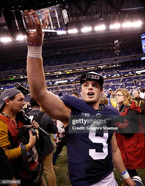 Trace McSorley of the Penn State Nittany Lions holds up the Most Valuable Player trophy as he walks off the field after the Big Ten Championship game...