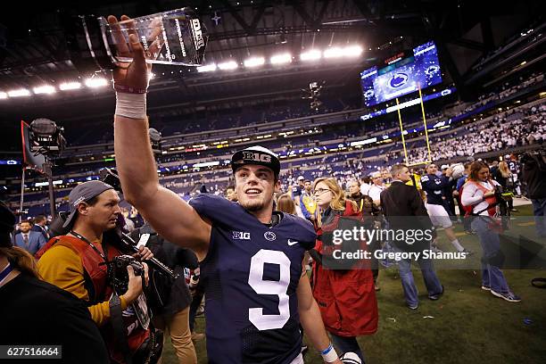 Trace McSorley of the Penn State Nittany Lions holds up the Most Valuable Player trophy as he walks off the field after the Big Ten Championship game...